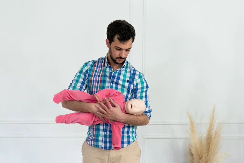 homme-mannequin-bebe Homme tenant un mannequin de bébé en formation PSC.